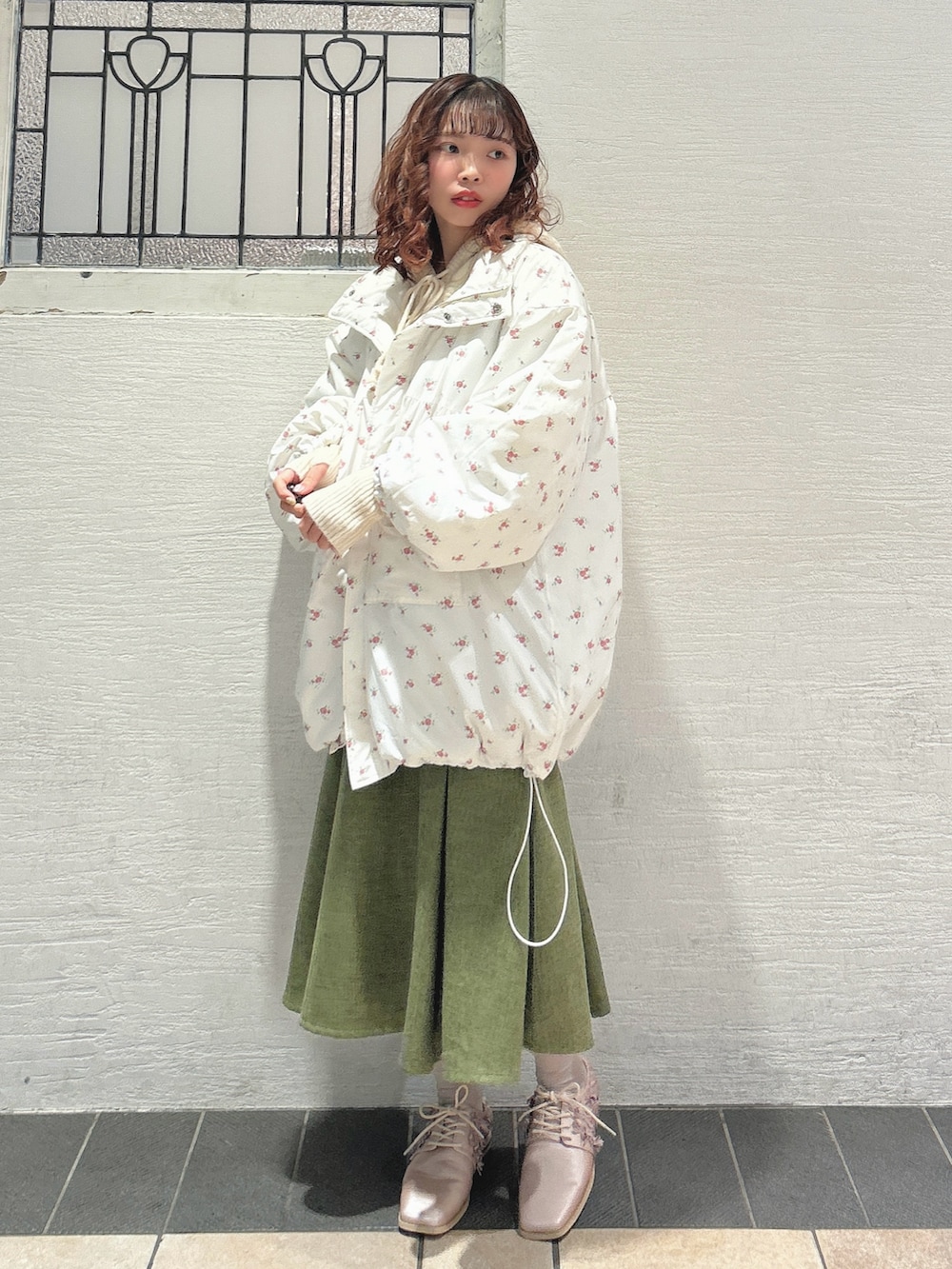 ピンク系のブルゾン、ホワイト系のニット/セーター、グリーン系のスカートを着用したレディースの秋コーディネートの4枚目の写真