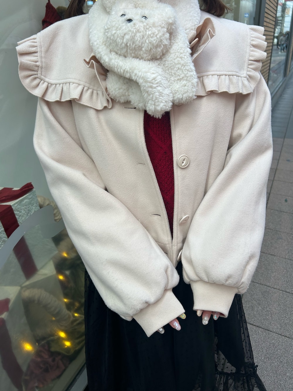 ホワイト系のブルゾン、レッド系のニット/セーター、ブラック系のワンピースを着用したレディースの冬コーディネートの5枚目の写真