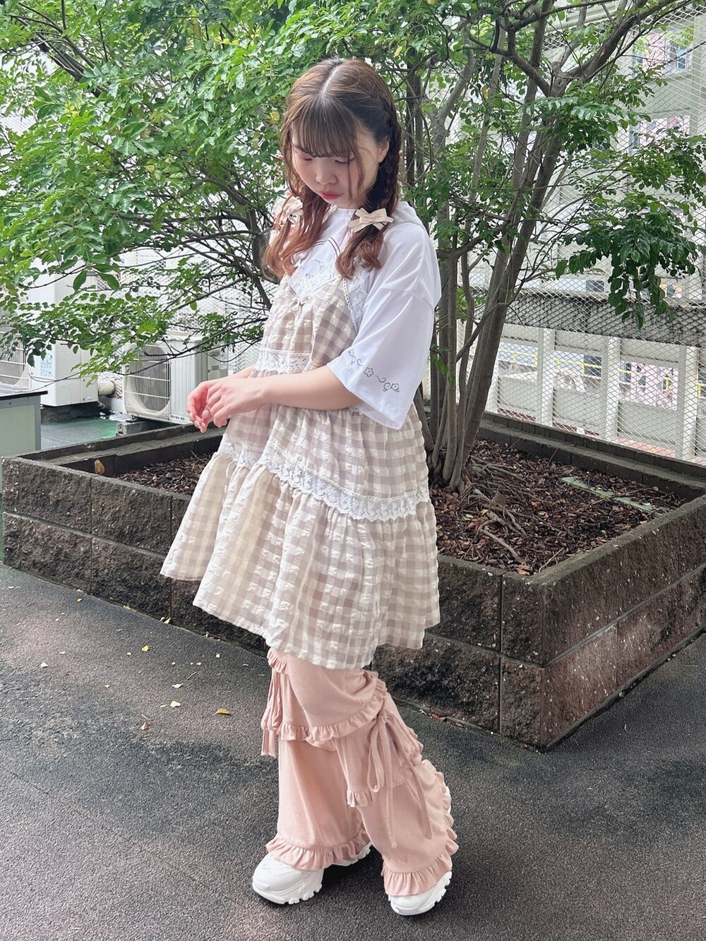 ピンク系のスウェットパンツ、ホワイト系のスニーカー、ベージュ系のキャミソールを着用したレディースの夏コーディネートの4枚目の写真