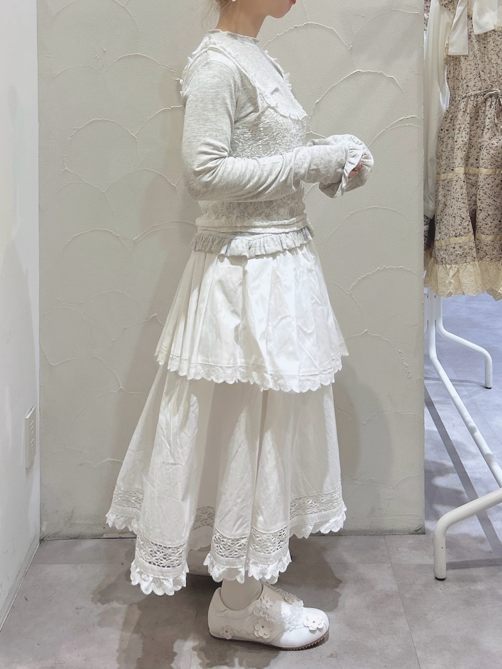 グレー系のTシャツ/カットソー、ホワイト系のスカート、ホワイト系のスニーカーを着用したレディースの冬コーディネートの4枚目の写真