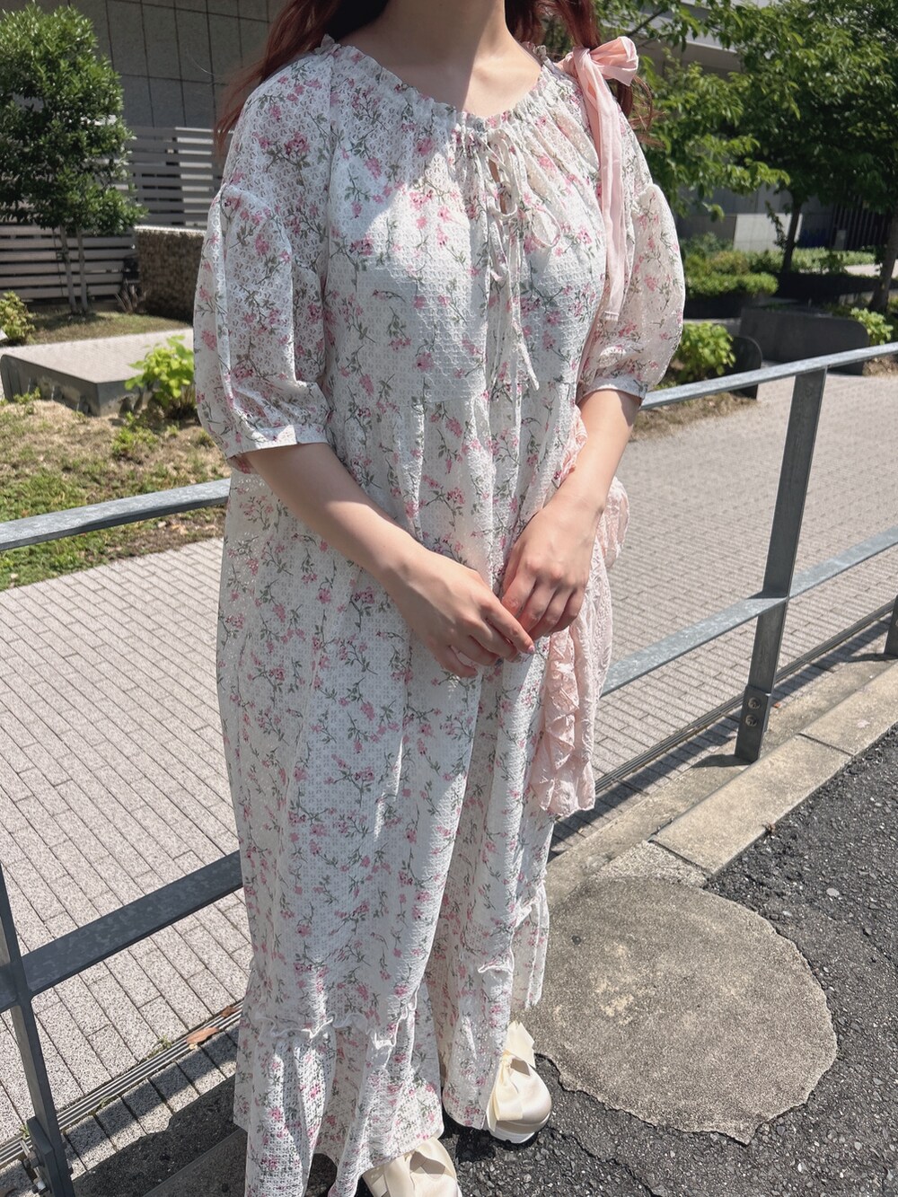 ピンク系のワンピース、ピンク系のトートバッグ、ホワイト系のスニーカーを着用したレディースの夏コーディネートの6枚目の写真