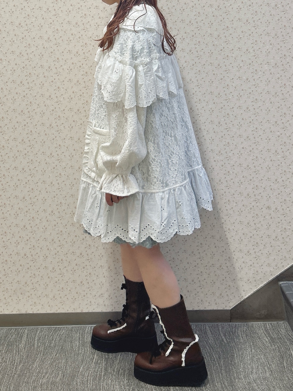 ホワイト系のテーラードジャケット、ブルー系のワンピース、ブラウン系のブーツを着用したレディースの秋コーディネートの3枚目の写真