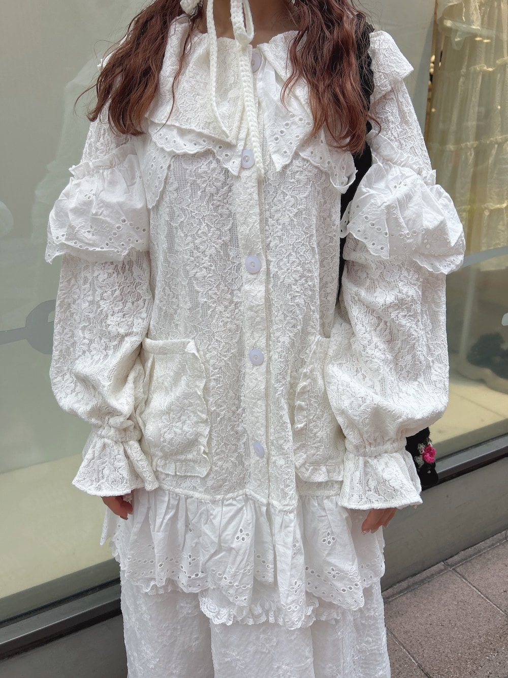 ホワイト系のテーラードジャケット、ホワイト系のスカート、ブラック系のショルダーバッグを着用したレディースの夏コーディネートの7枚目の写真