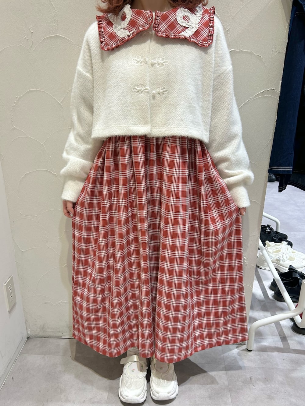 レッド系のワンピース、ホワイト系のカーディガン/ボレロ、ホワイト系のスニーカーを着用したレディースの秋コーディネートの7枚目の写真