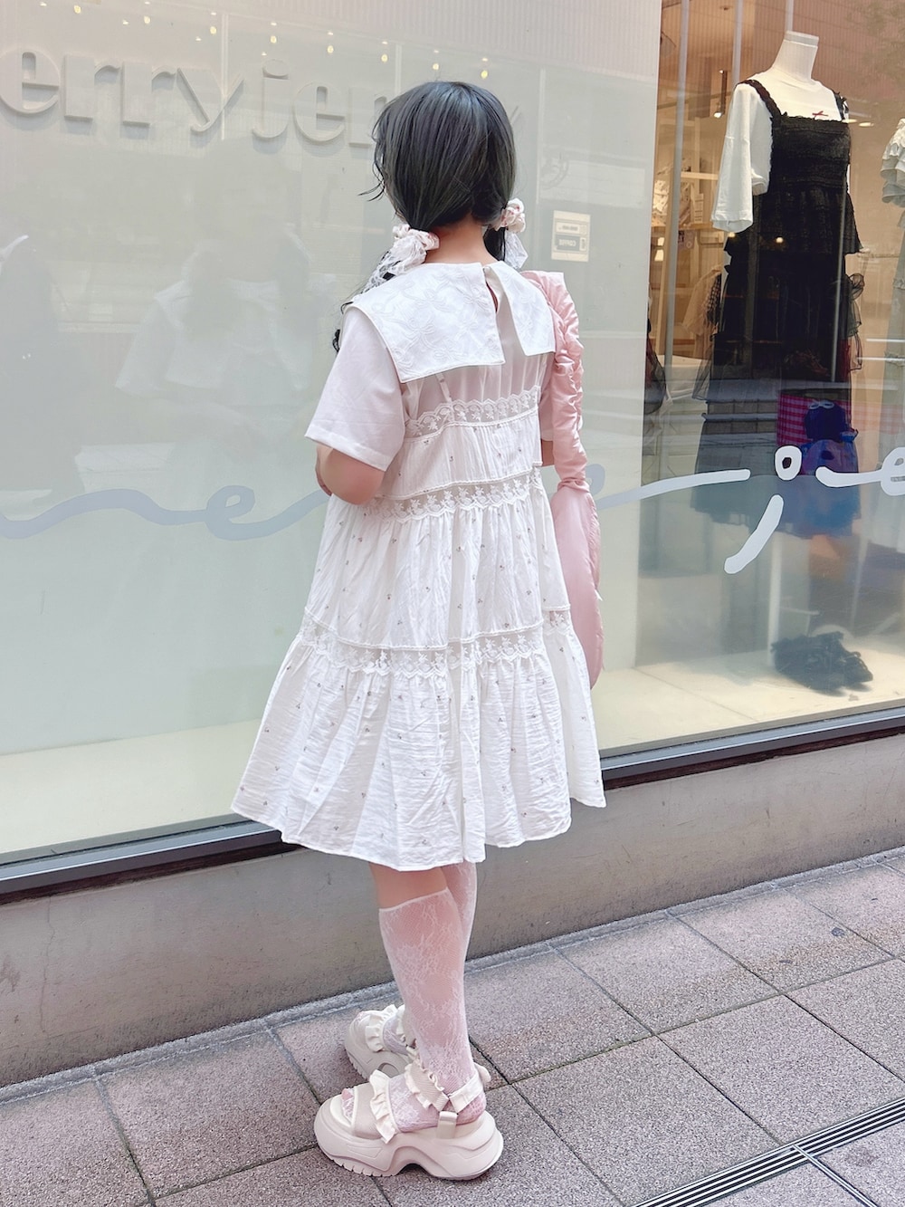 ピンク系のキャミソール、ホワイト系のワンピース、ピンク系のショルダーバッグを着用したレディースの夏コーディネートの2枚目の写真