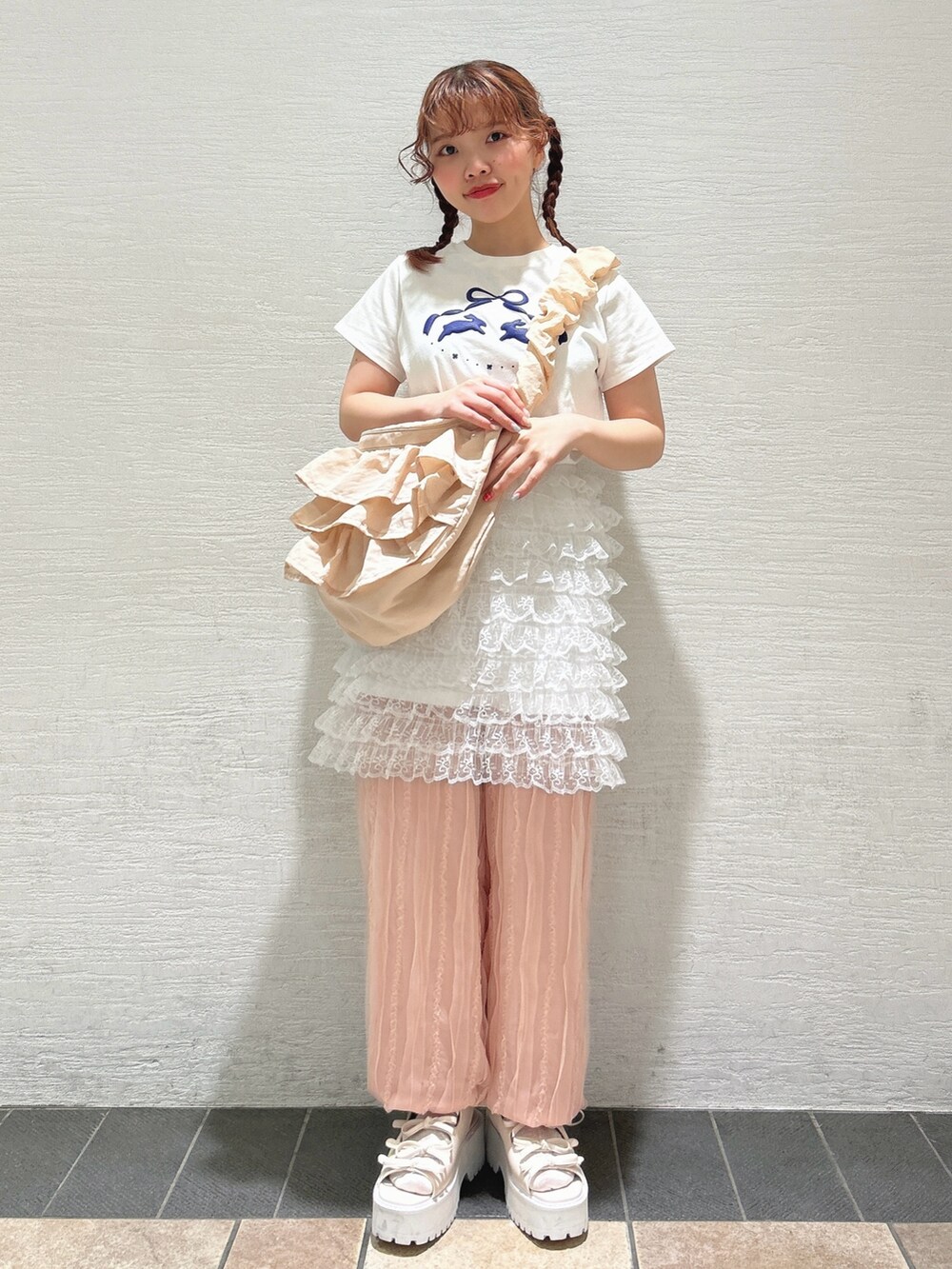 ホワイト系のスカート、ホワイト系のTシャツ/カットソー、ピンク系のショルダーバッグを着用したレディースの夏コーディネートの2枚目の写真