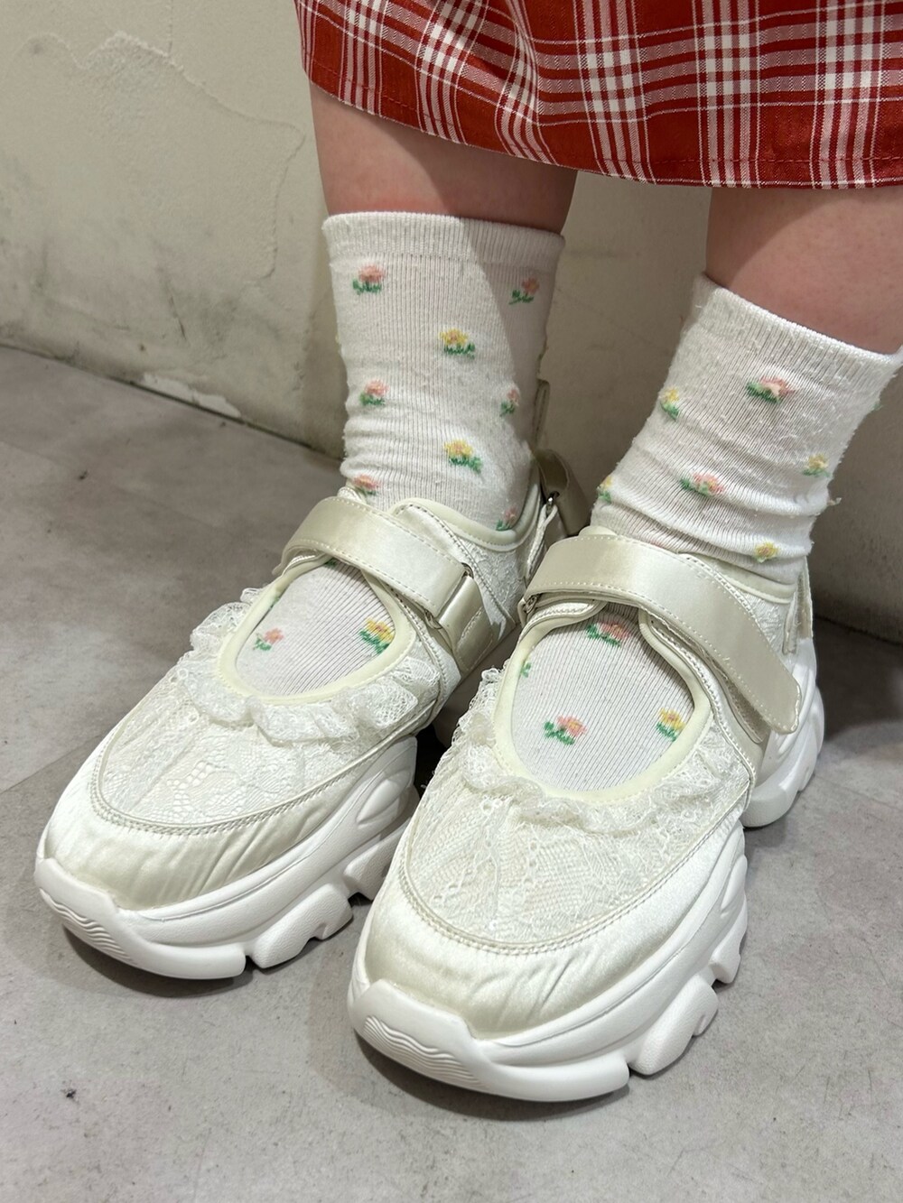 レッド系のワンピース、ホワイト系のカーディガン/ボレロ、ホワイト系のスニーカーを着用したレディースの秋コーディネートの8枚目の写真