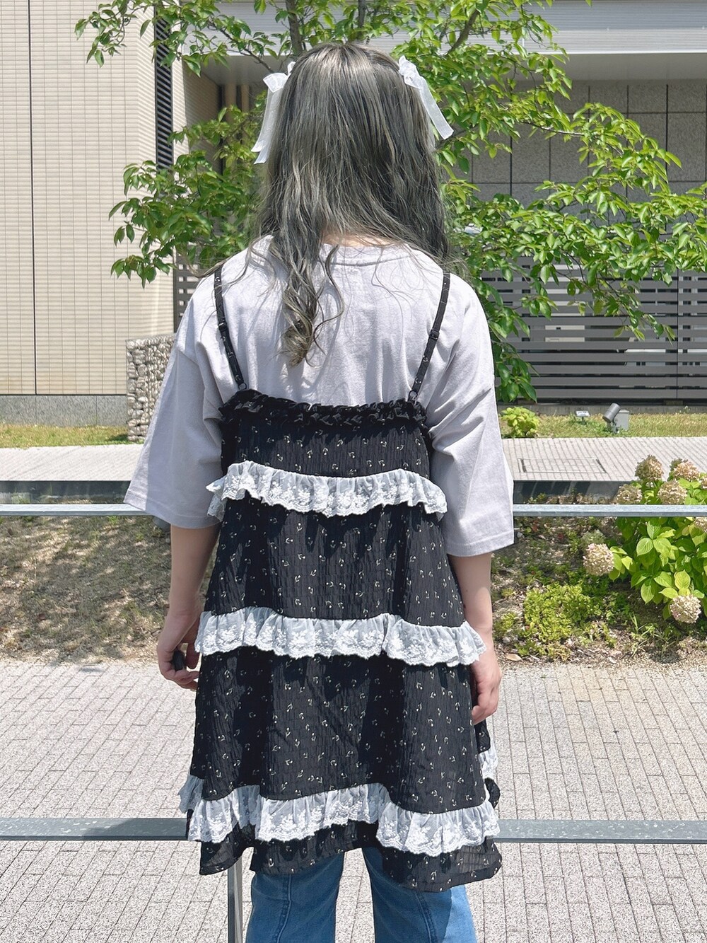 ブラック系のチュニック、パープル系のTシャツ/カットソー、ブルー系のデニムパンツを着用したレディースの夏コーディネートの6枚目の写真
