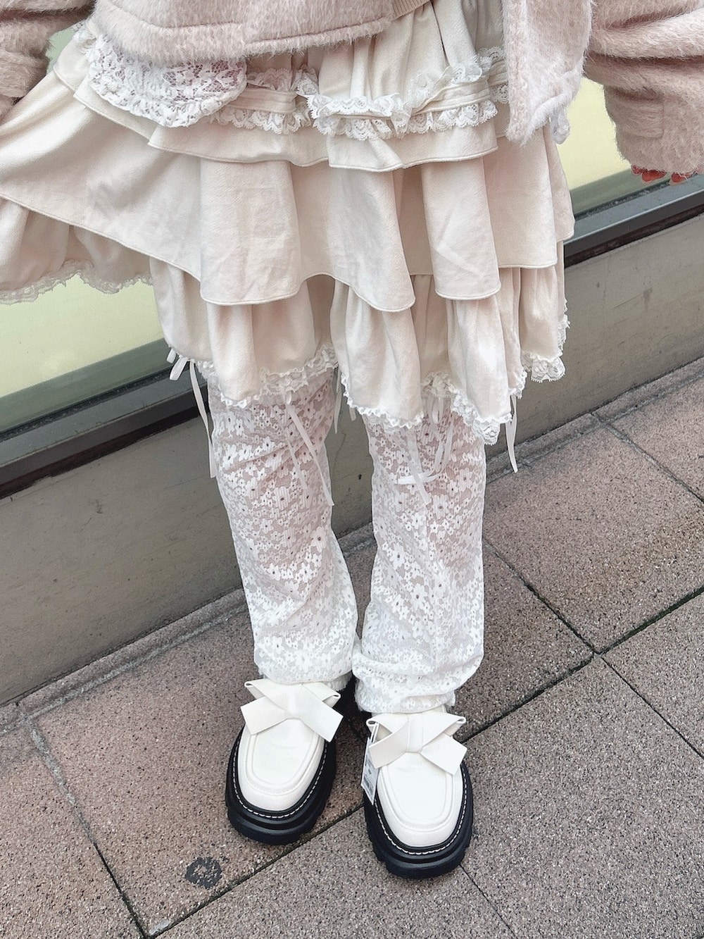 ホワイト系のスカート、ピンク系のダッフルコート、ホワイト系のカーディガン/ボレロを着用したレディースの秋コーディネートの9枚目の写真