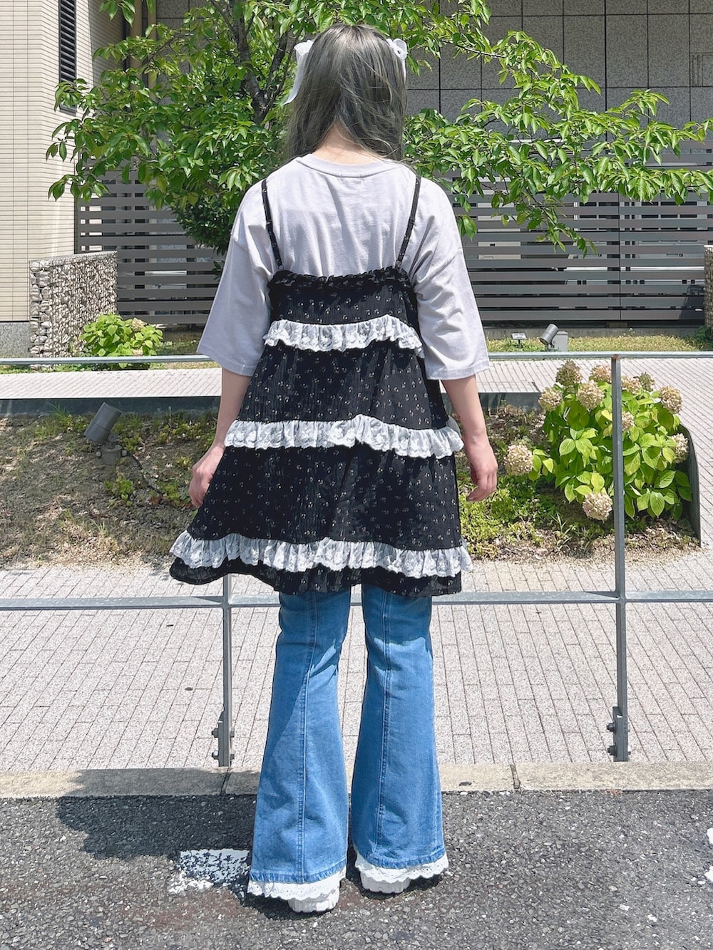 ブラック系のチュニック、パープル系のTシャツ/カットソー、ブルー系のデニムパンツを着用したレディースの夏コーディネートの2枚目の写真