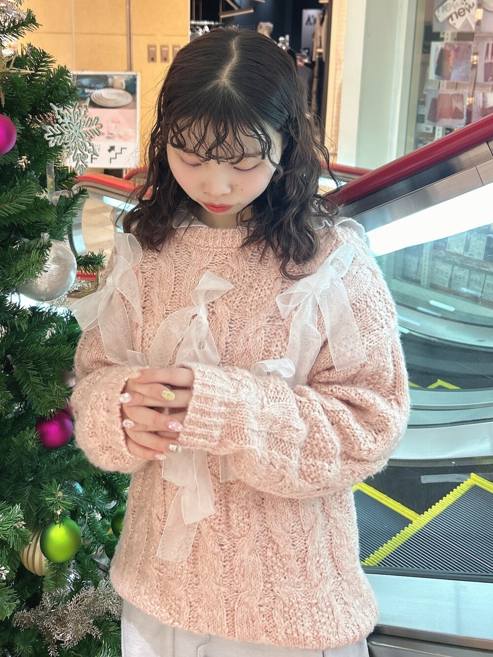 ピンク系のニット/セーター、ブルー系のワンピース、ブルー系のデニムパンツを着用したレディースの冬コーディネートの3枚目の写真