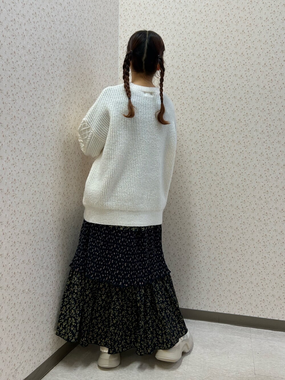 ピンク系のブルゾン、ホワイト系のニット/セーター、ブラック系のスカートを着用したレディースの冬コーディネートの6枚目の写真