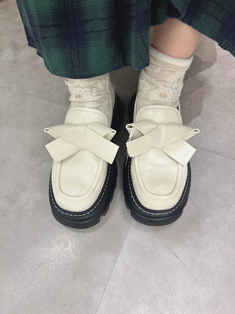 ブルー系のニット/セーター、ホワイト系のシャツ/ブラウス、グリーン系のスカートを着用したレディースの秋コーディネートの10枚目の写真