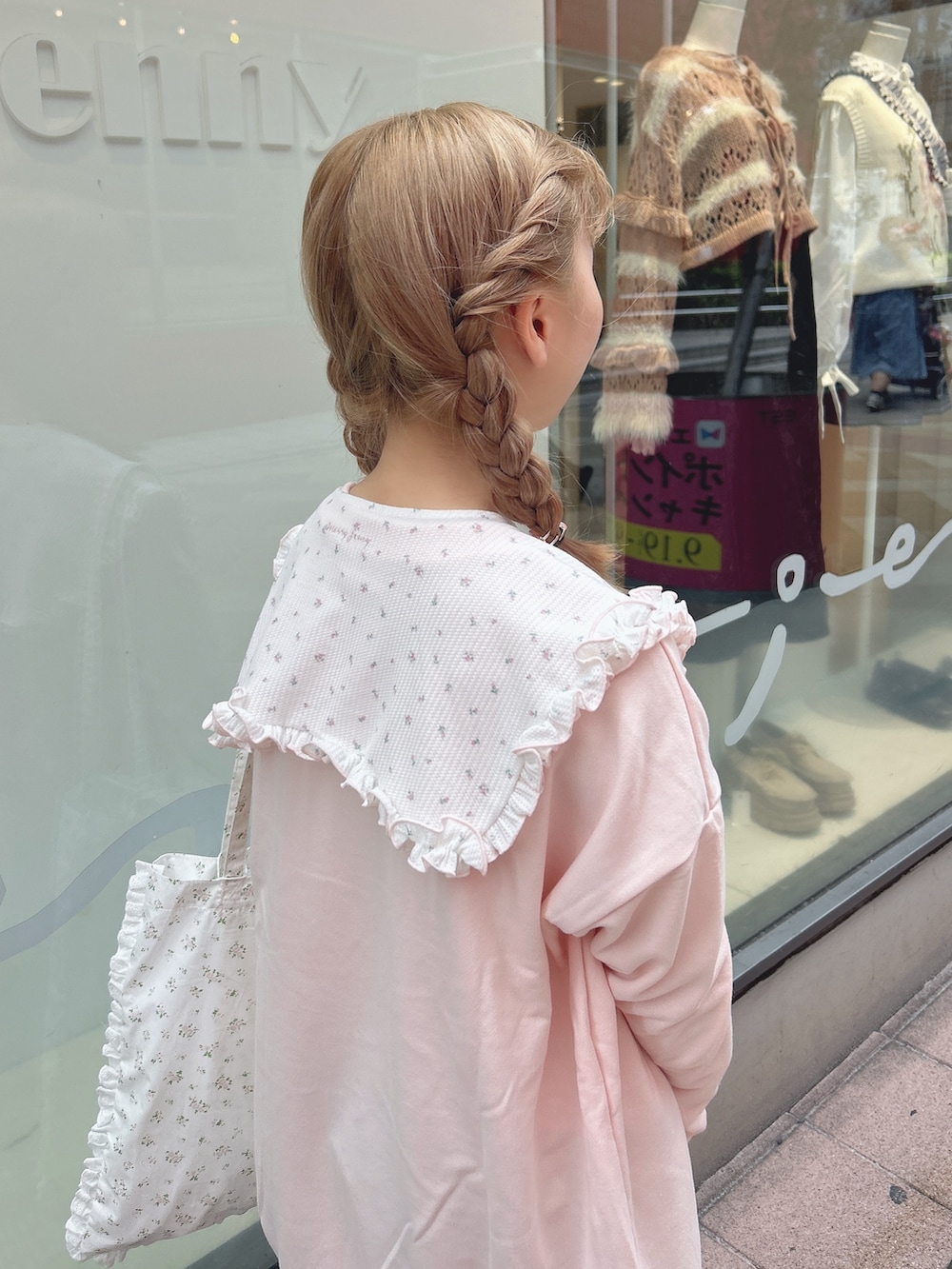 ピンク系のスウェット、ブルー系のデニムパンツ、ホワイト系のトートバッグを着用したレディースの秋コーディネートの6枚目の写真