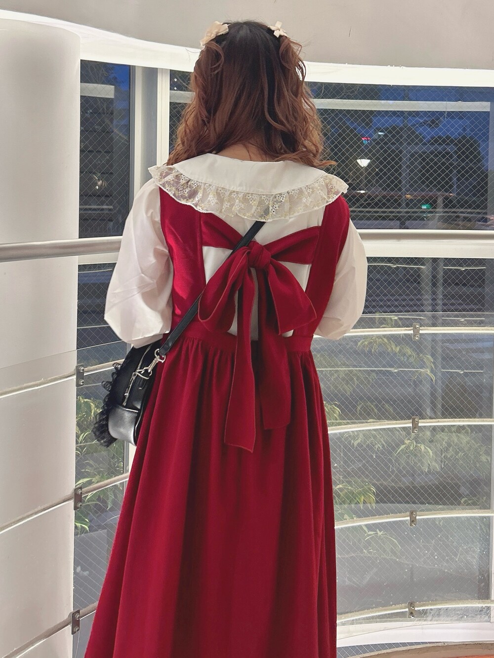 レッド系のワンピース、ゴールド系のシャツ/ブラウス、ブラック系のショルダーバッグを着用したレディースの秋コーディネートの6枚目の写真