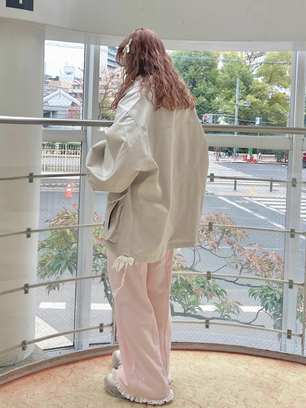 ホワイト系のブルゾン、グリーン系のTシャツ/カットソー、ピンク系のスウェットパンツを着用したレディースの冬コーディネートの3枚目の写真