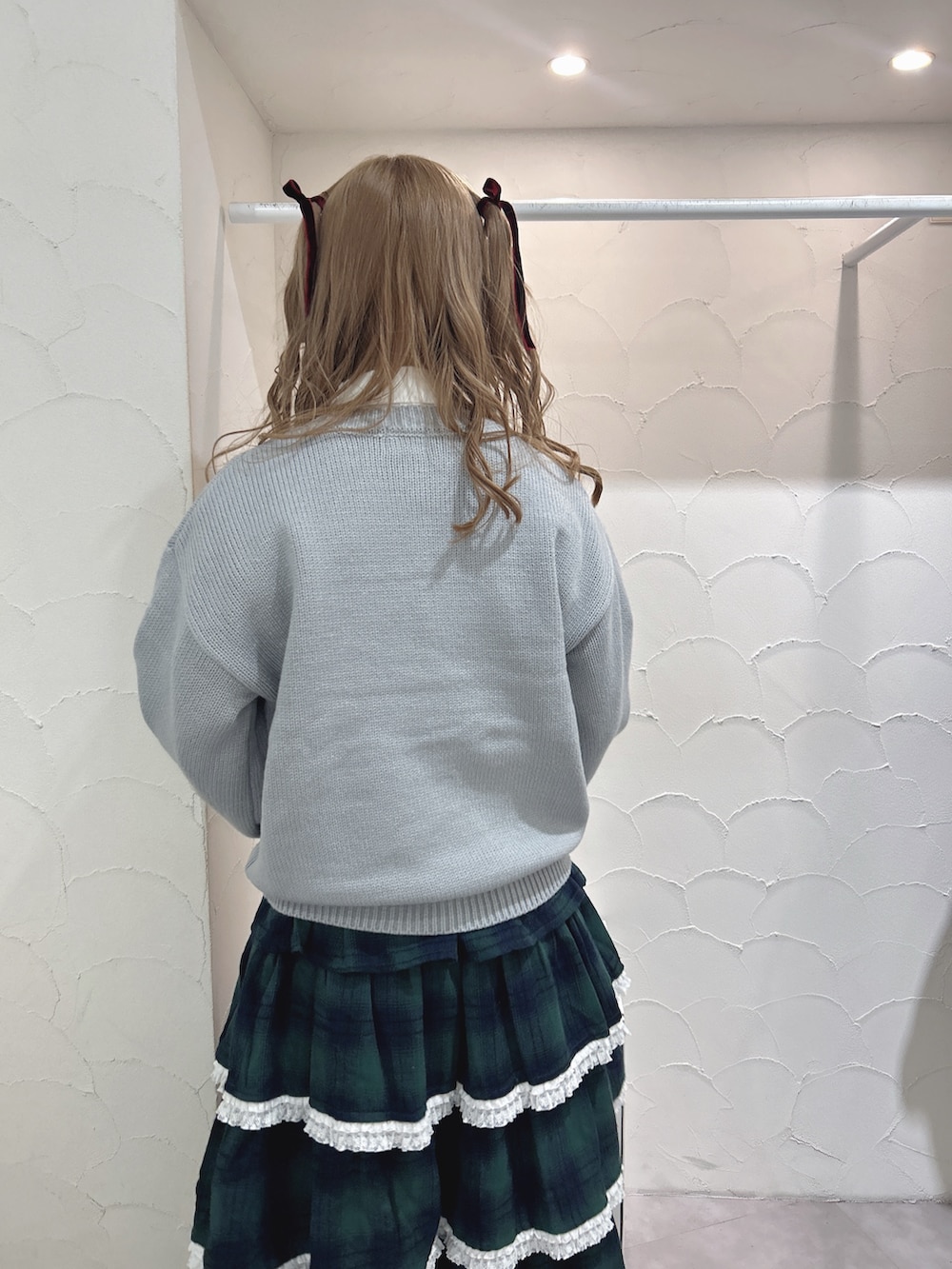 ブルー系のニット/セーター、ホワイト系のシャツ/ブラウス、グリーン系のスカートを着用したレディースの秋コーディネートの5枚目の写真