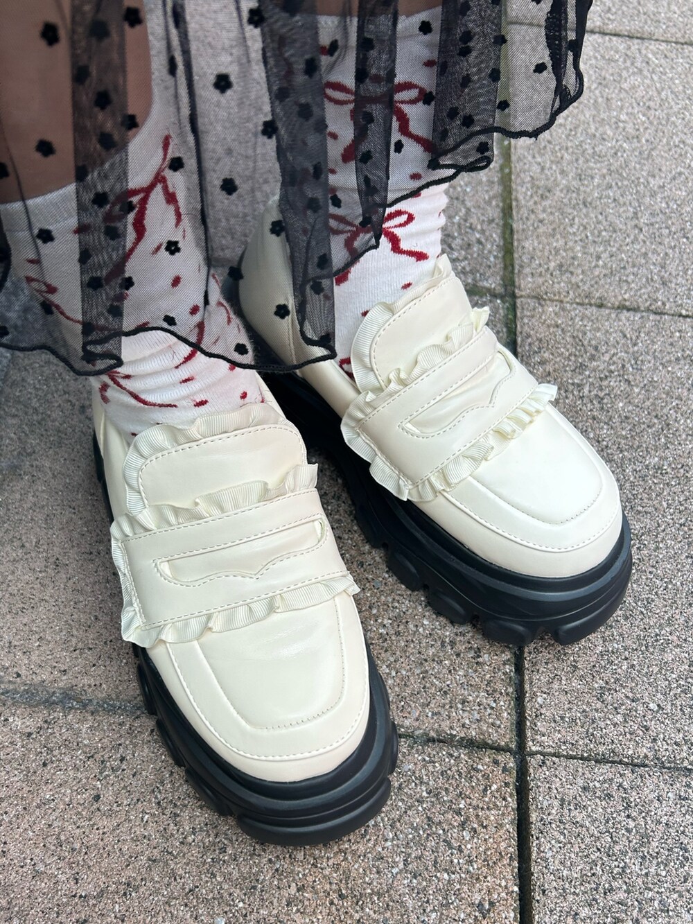 ホワイト系のブルゾン、レッド系のニット/セーター、ブラック系のワンピースを着用したレディースの冬コーディネートの10枚目の写真