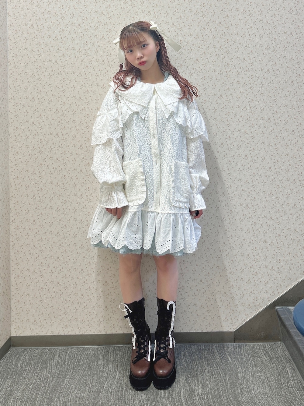 ホワイト系のテーラードジャケット、ブルー系のワンピース、ブラウン系のブーツを着用したレディースの秋コーディネートの2枚目の写真