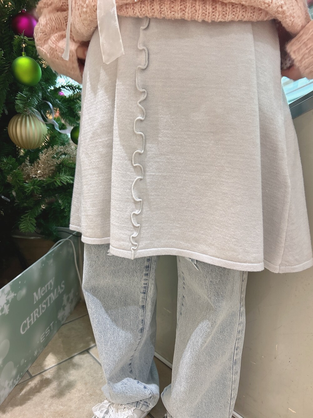 ピンク系のニット/セーター、ブルー系のワンピース、ブルー系のデニムパンツを着用したレディースの冬コーディネートの8枚目の写真