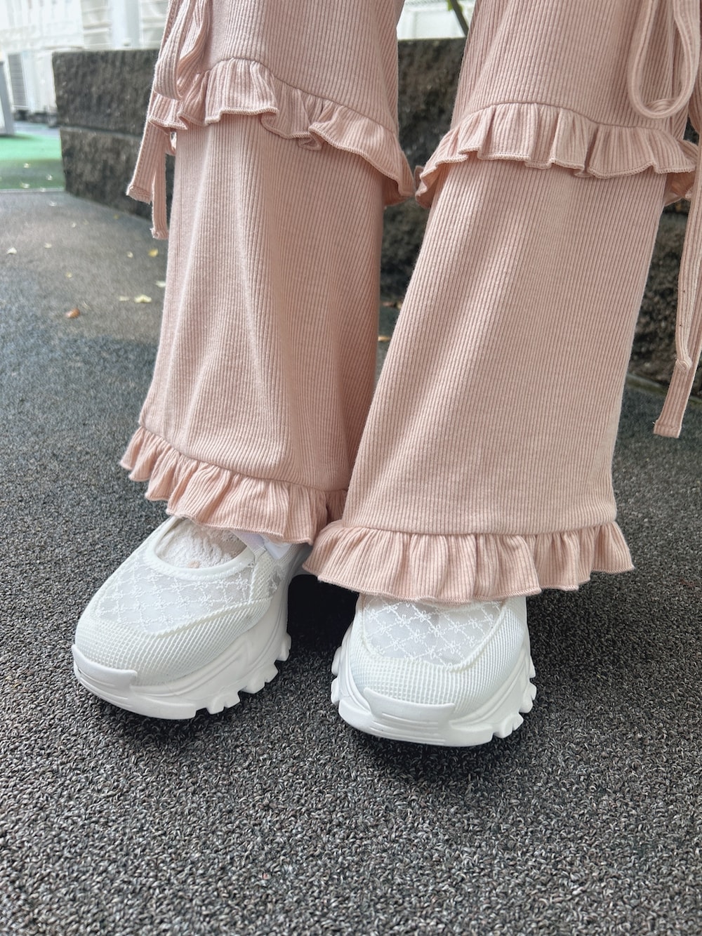 ピンク系のスウェットパンツ、ホワイト系のスニーカー、ベージュ系のキャミソールを着用したレディースの夏コーディネートの10枚目の写真