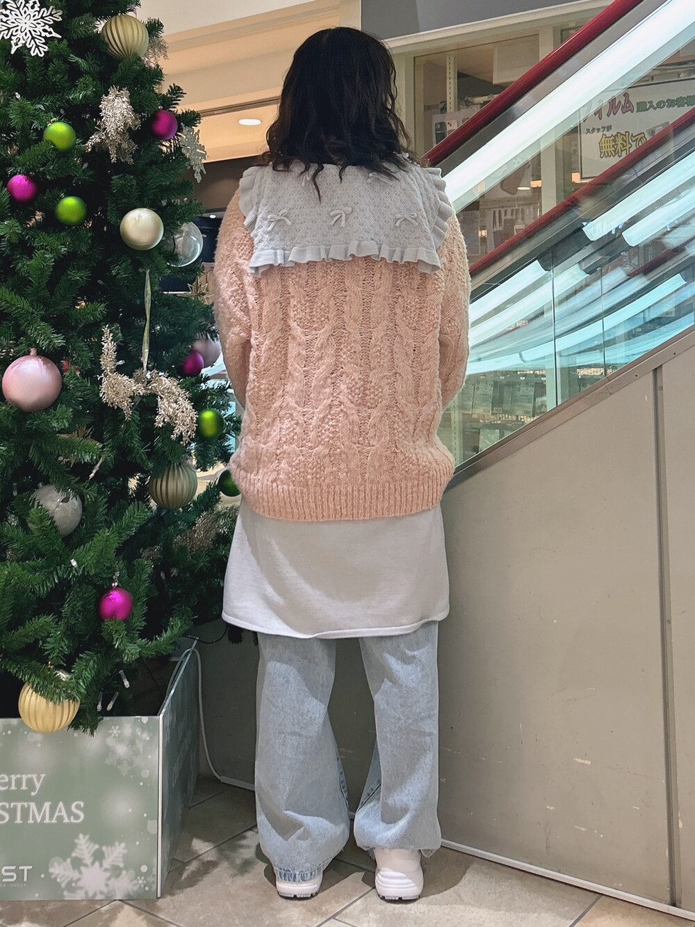 ピンク系のニット/セーター、ブルー系のワンピース、ブルー系のデニムパンツを着用したレディースの冬コーディネートの2枚目の写真