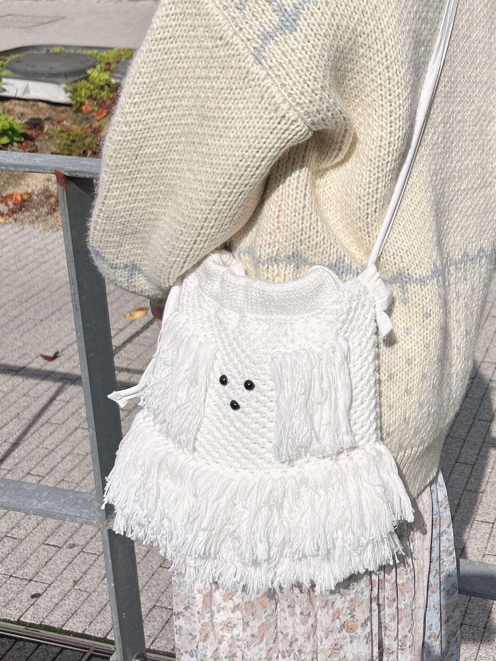 ホワイト系のカーディガン/ボレロ、ホワイト系のニット/セーター、ホワイト系のスカートを着用したレディースの秋コーディネートの9枚目の写真