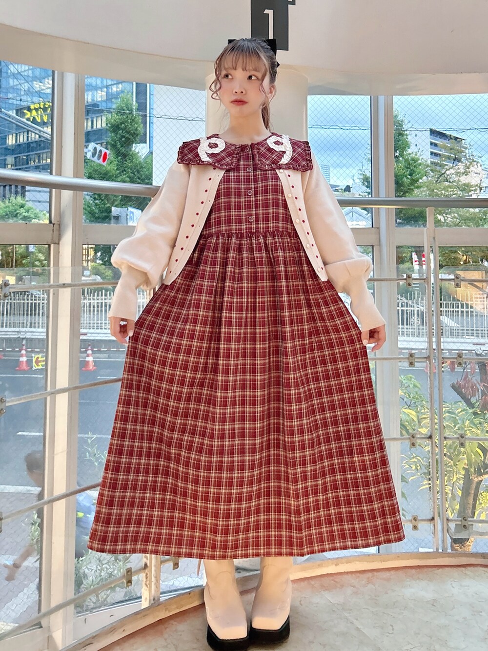 レッド系のワンピース、ホワイト系のカーディガン/ボレロ、ピンク系のブーツを着用したレディースの秋コーディネートの2枚目の写真