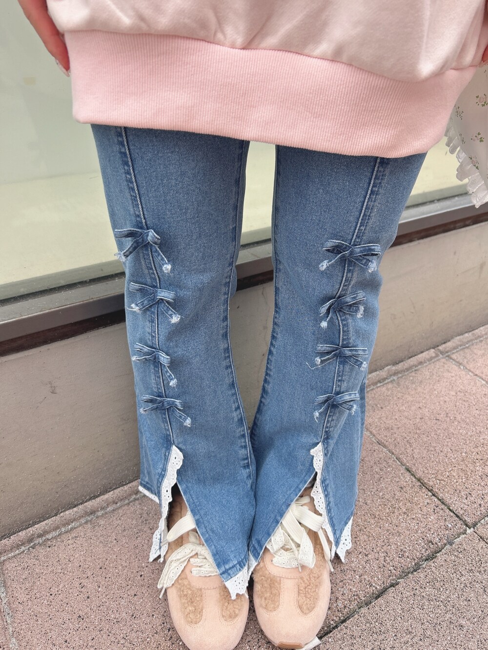 ピンク系のスウェット、ブルー系のデニムパンツ、ホワイト系のトートバッグを着用したレディースの秋コーディネートの9枚目の写真