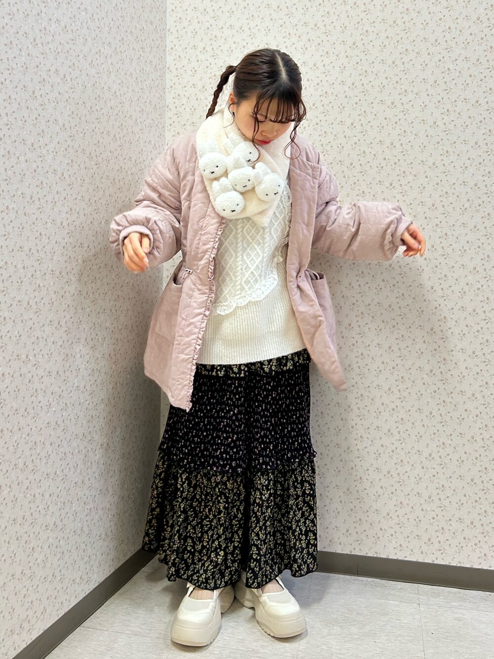 ピンク系のブルゾン、ホワイト系のニット/セーター、ブラック系のスカートを着用したレディースの冬コーディネートの2枚目の写真