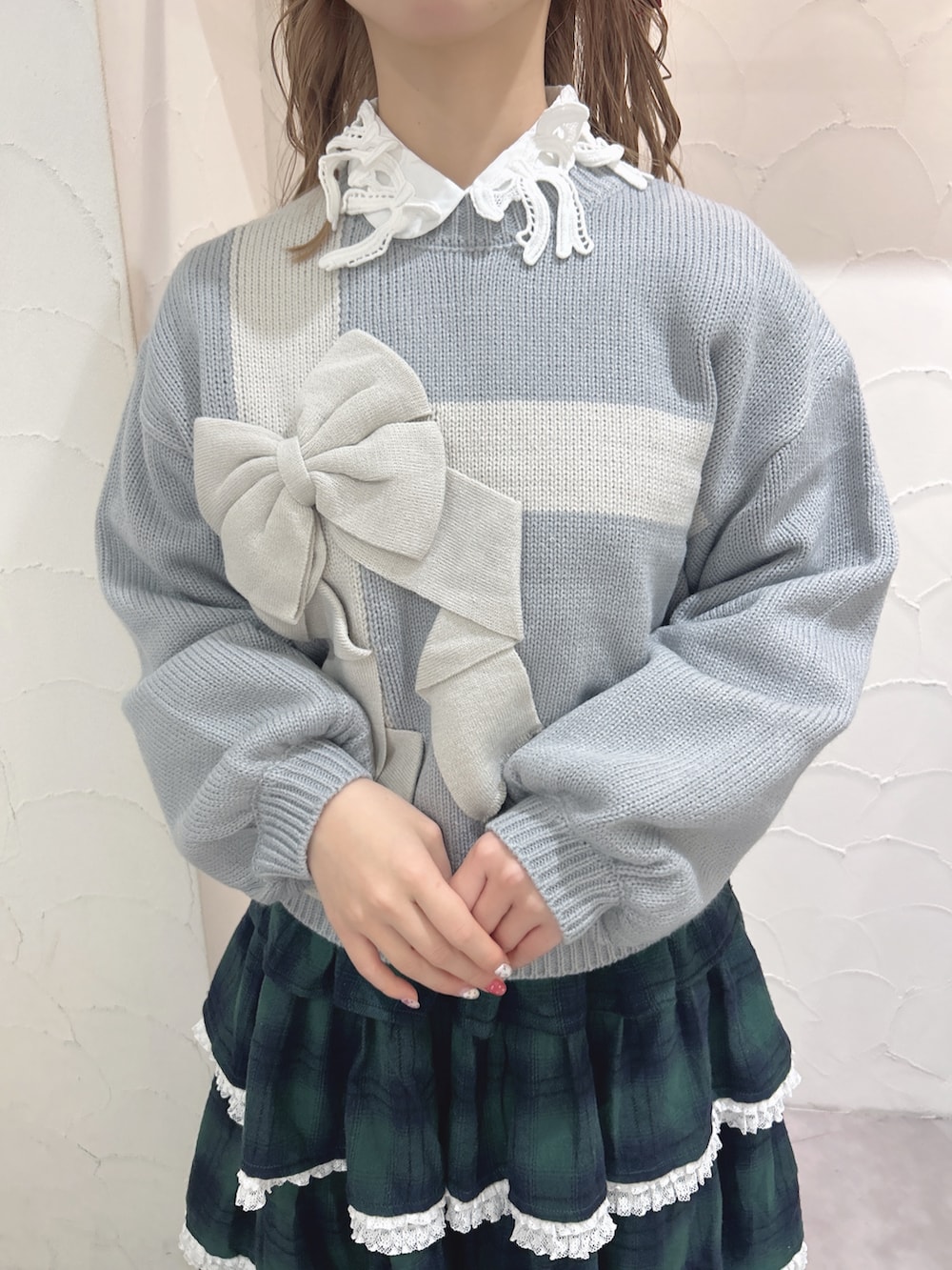 ブルー系のニット/セーター、ホワイト系のシャツ/ブラウス、グリーン系のスカートを着用したレディースの秋コーディネートの8枚目の写真