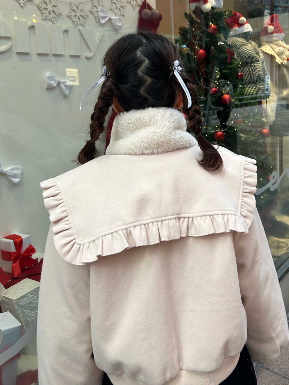 ホワイト系のブルゾン、レッド系のニット/セーター、ブラック系のワンピースを着用したレディースの冬コーディネートの4枚目の写真