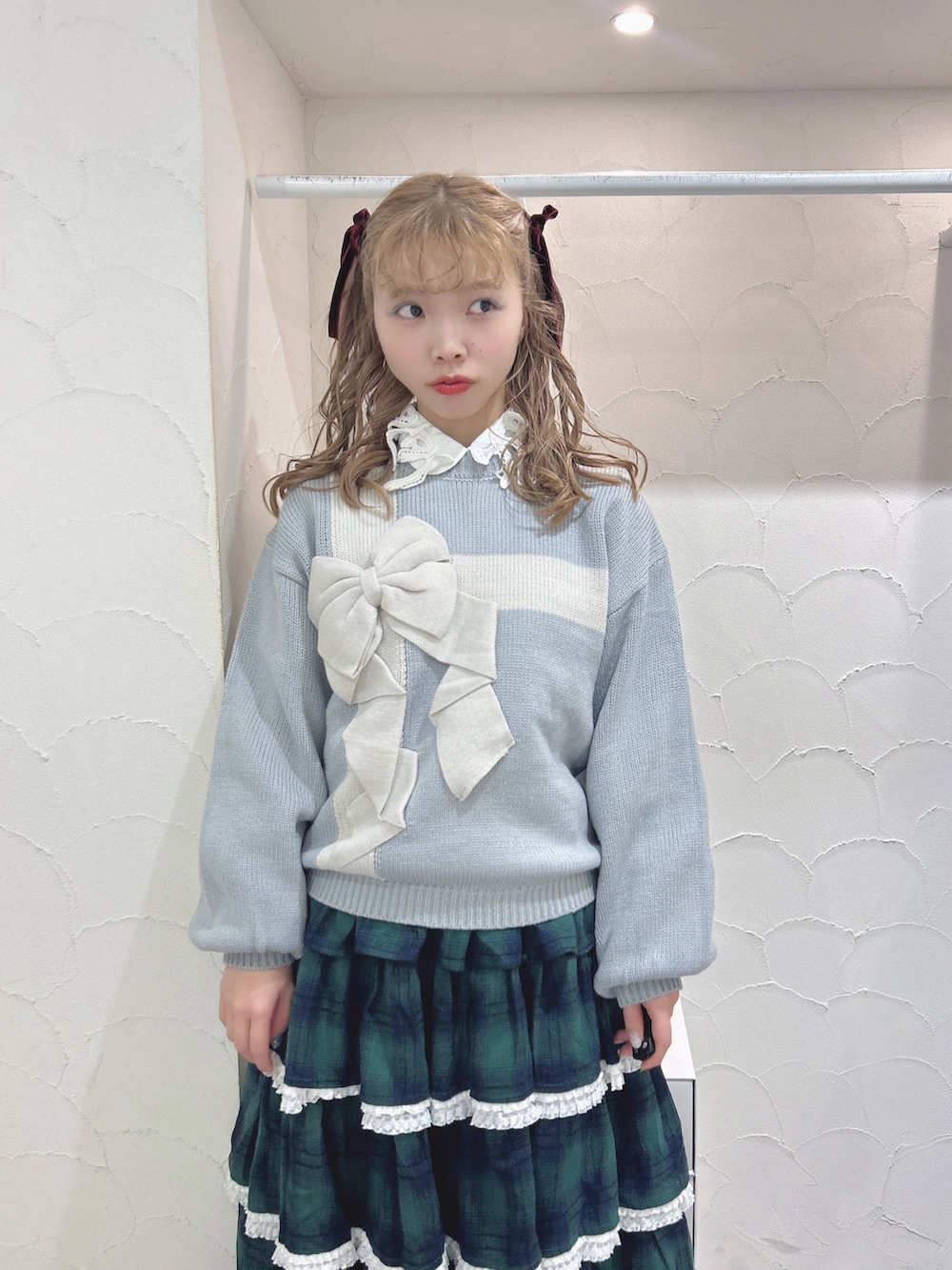 ブルー系のニット/セーター、ホワイト系のシャツ/ブラウス、グリーン系のスカートを着用したレディースの秋コーディネートの4枚目の写真