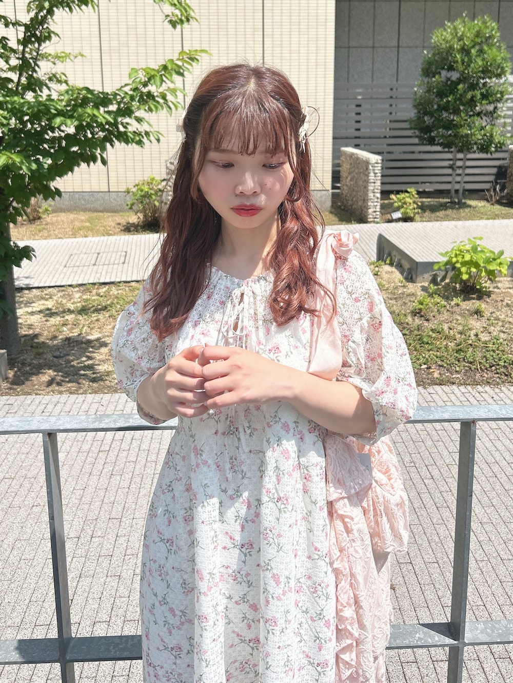 ピンク系のワンピース、ピンク系のトートバッグ、ホワイト系のスニーカーを着用したレディースの夏コーディネートの4枚目の写真