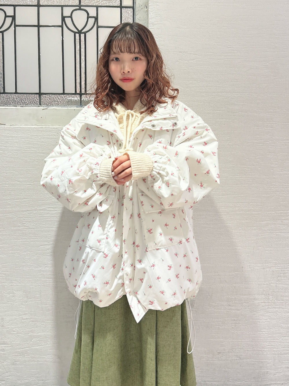 ピンク系のブルゾン、ホワイト系のニット/セーター、グリーン系のスカートを着用したレディースの秋コーディネートの5枚目の写真