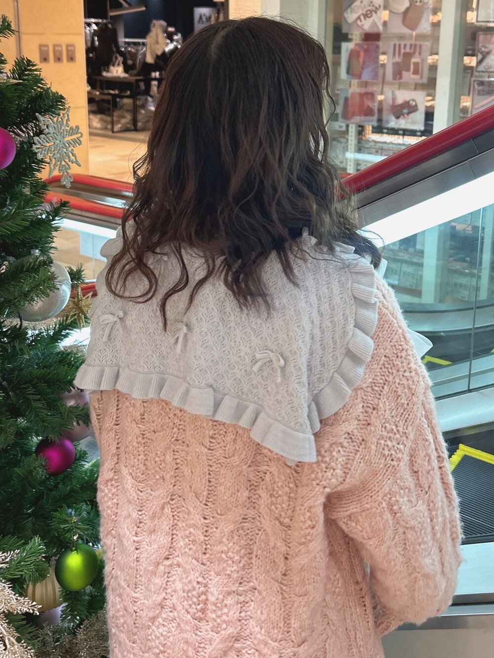 ピンク系のニット/セーター、ブルー系のワンピース、ブルー系のデニムパンツを着用したレディースの冬コーディネートの4枚目の写真