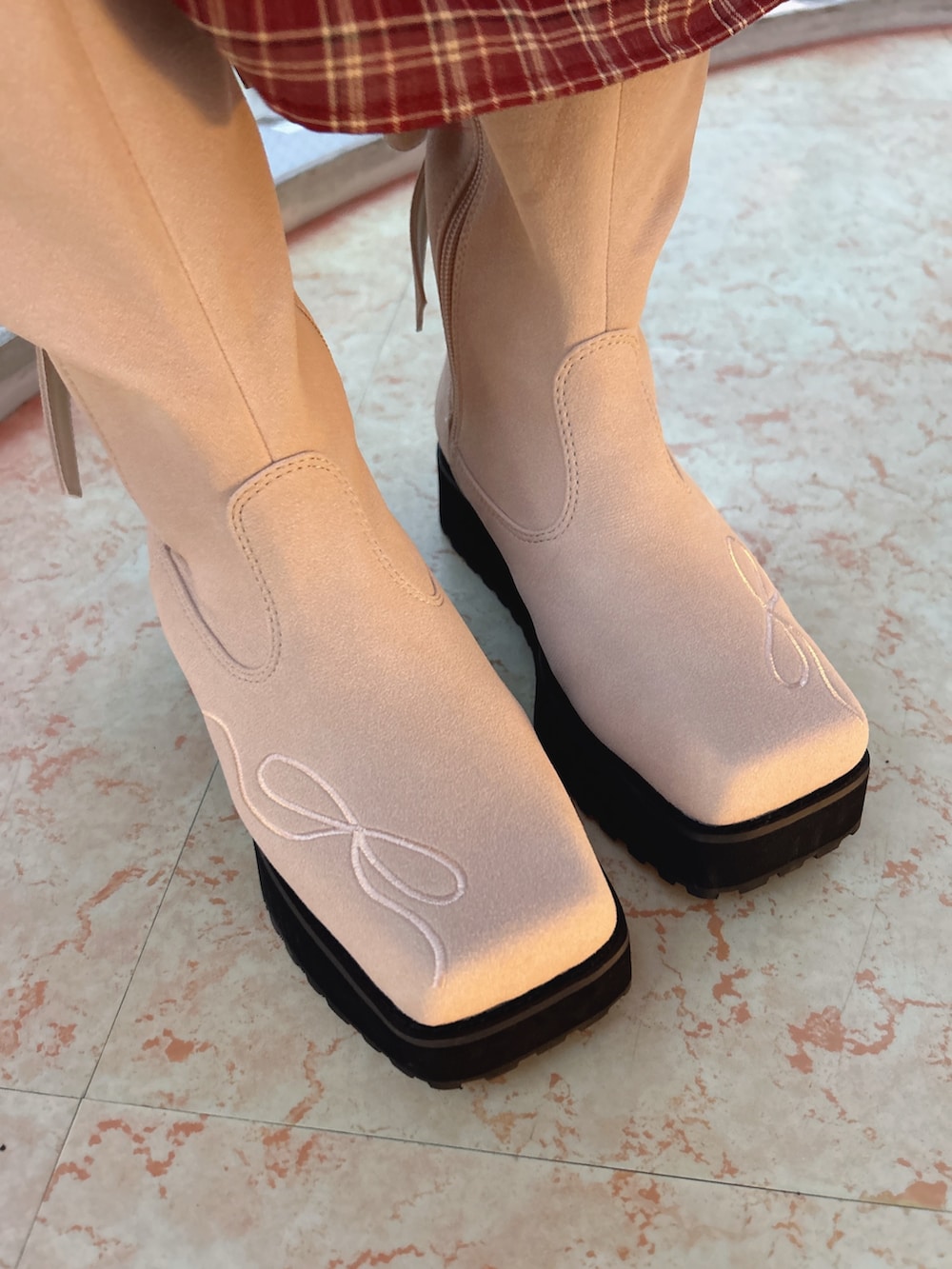 レッド系のワンピース、ホワイト系のカーディガン/ボレロ、ピンク系のブーツを着用したレディースの秋コーディネートの10枚目の写真