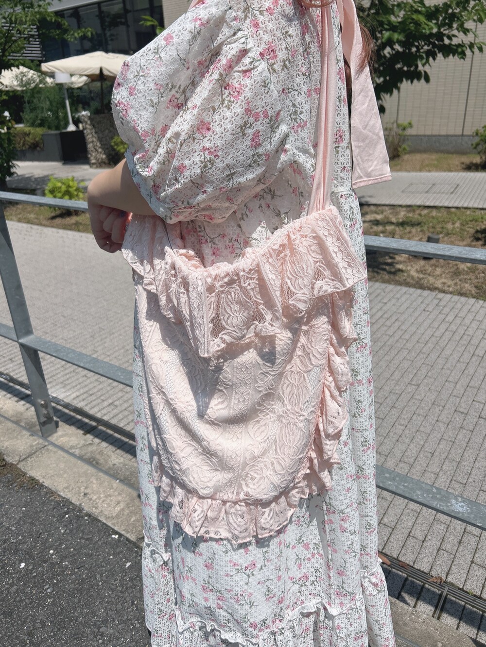 ピンク系のワンピース、ピンク系のトートバッグ、ホワイト系のスニーカーを着用したレディースの夏コーディネートの7枚目の写真