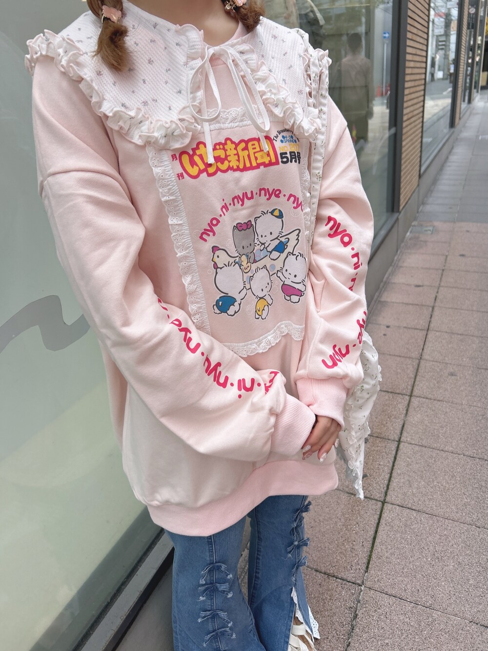 ピンク系のスウェット、ブルー系のデニムパンツ、ホワイト系のトートバッグを着用したレディースの秋コーディネートの7枚目の写真