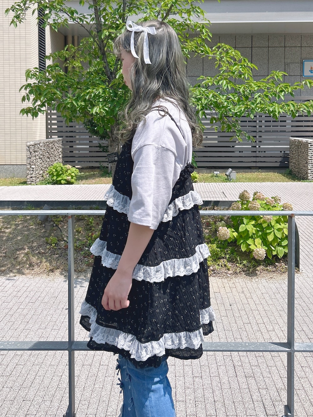 ブラック系のチュニック、パープル系のTシャツ/カットソー、ブルー系のデニムパンツを着用したレディースの夏コーディネートの5枚目の写真