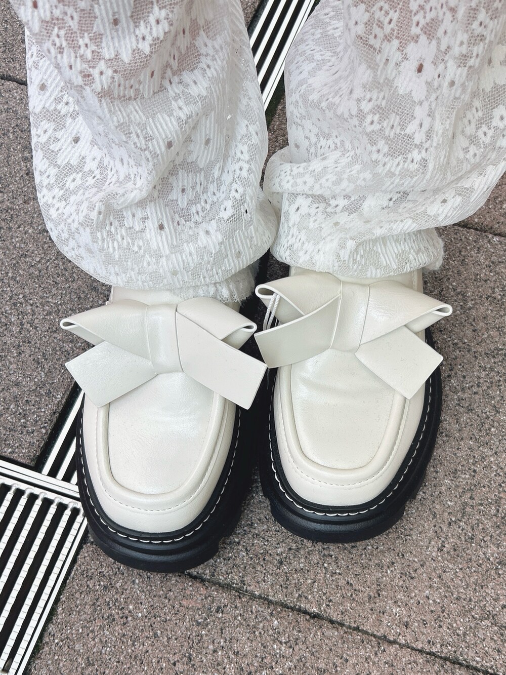 ホワイト系のスカート、ピンク系のダッフルコート、ホワイト系のカーディガン/ボレロを着用したレディースの秋コーディネートの10枚目の写真