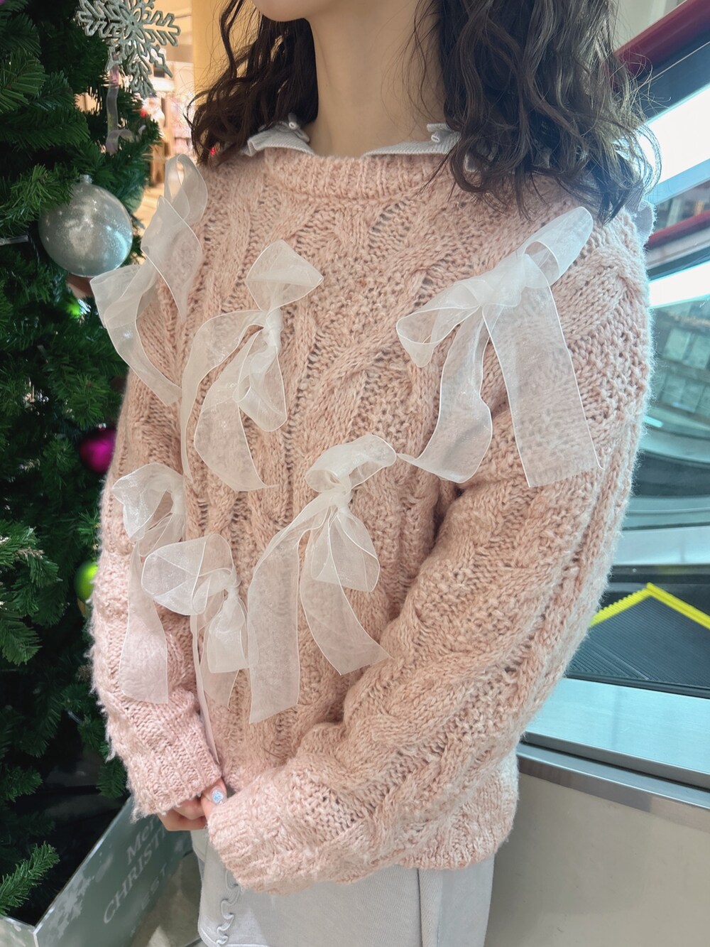 ピンク系のニット/セーター、ブルー系のワンピース、ブルー系のデニムパンツを着用したレディースの冬コーディネートの6枚目の写真