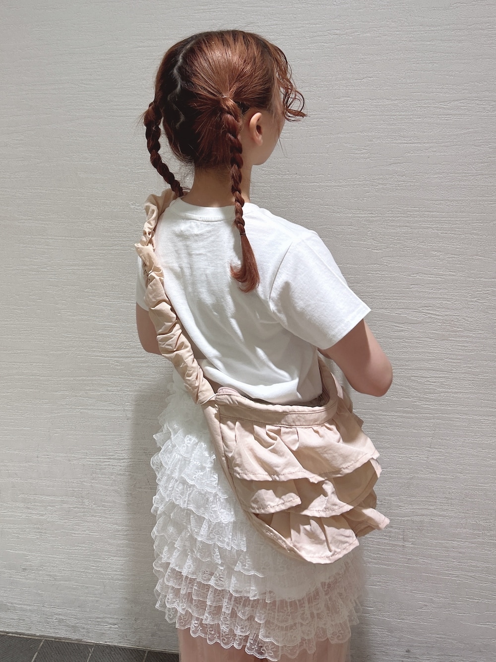 ホワイト系のスカート、ホワイト系のTシャツ/カットソー、ピンク系のショルダーバッグを着用したレディースの夏コーディネートの6枚目の写真