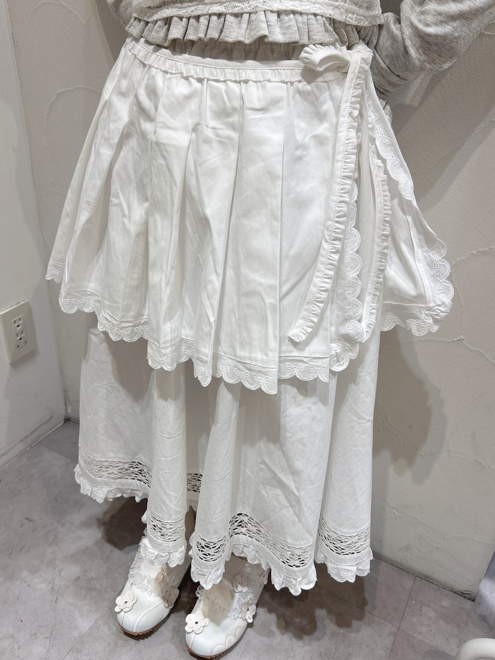 グレー系のTシャツ/カットソー、ホワイト系のスカート、ホワイト系のスニーカーを着用したレディースの冬コーディネートの9枚目の写真