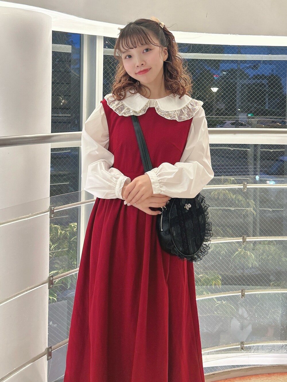 レッド系のワンピース、ゴールド系のシャツ/ブラウス、ブラック系のショルダーバッグを着用したレディースの秋コーディネートの4枚目の写真