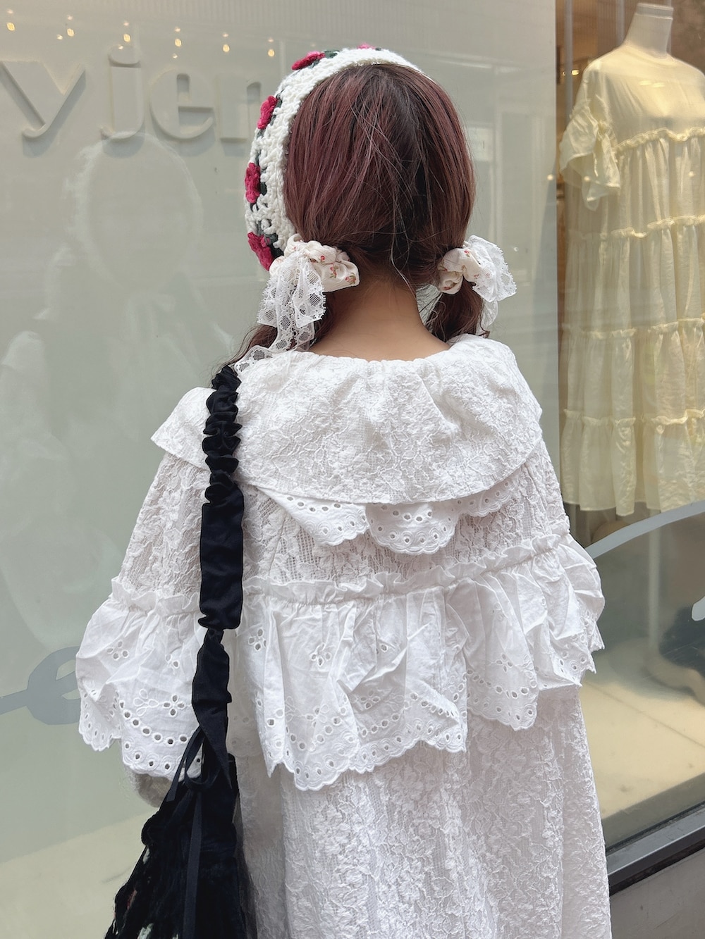 ホワイト系のテーラードジャケット、ホワイト系のスカート、ブラック系のショルダーバッグを着用したレディースの夏コーディネートの6枚目の写真