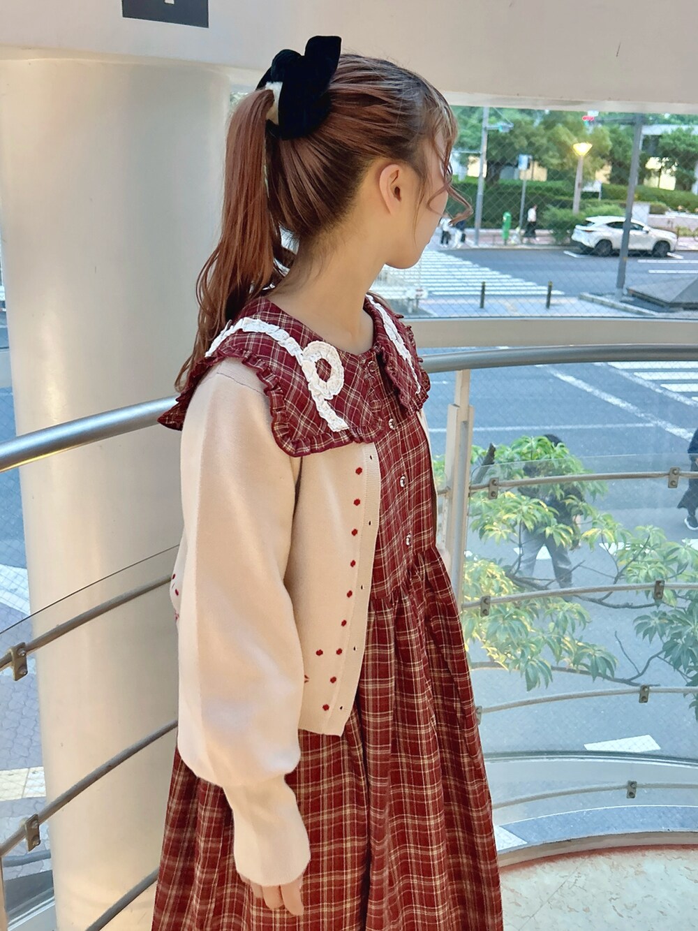 レッド系のワンピース、ホワイト系のカーディガン/ボレロ、ピンク系のブーツを着用したレディースの秋コーディネートの6枚目の写真