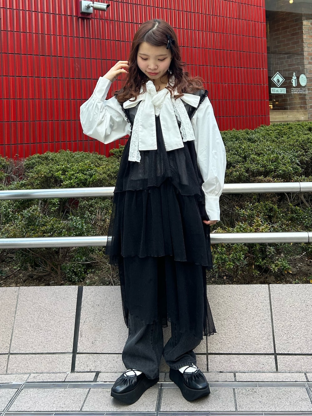 ホワイト系のシャツ/ブラウス、ブラック系のワンピース、ブラック系のデニムパンツを着用したレディースの冬コーディネートの3枚目の写真