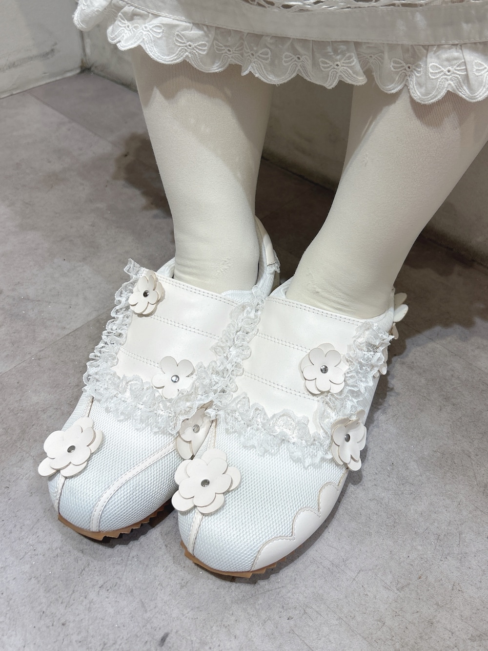 グレー系のTシャツ/カットソー、ホワイト系のスカート、ホワイト系のスニーカーを着用したレディースの冬コーディネートの10枚目の写真