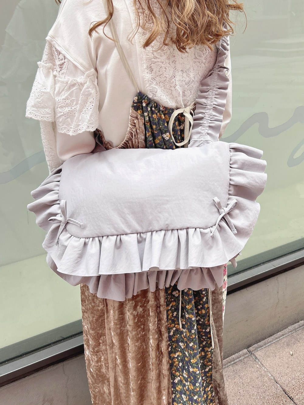 ホワイト系のジャージ、ピンク系のワンピース、ブルー系のショルダーバッグを着用したレディースの秋コーディネートの9枚目の写真